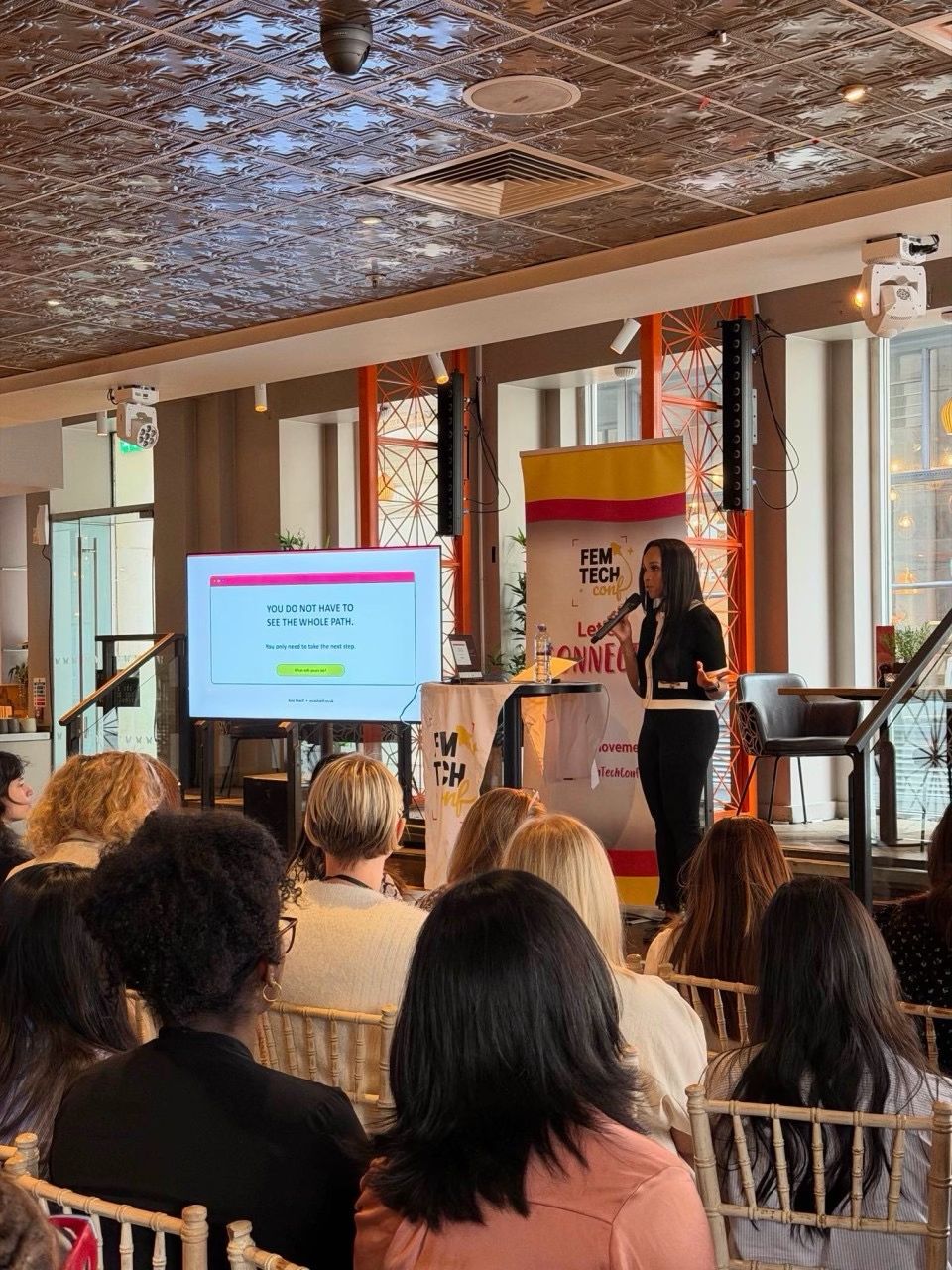 Speaker presenting on stage at the 2026 Women in Tech London Summit
